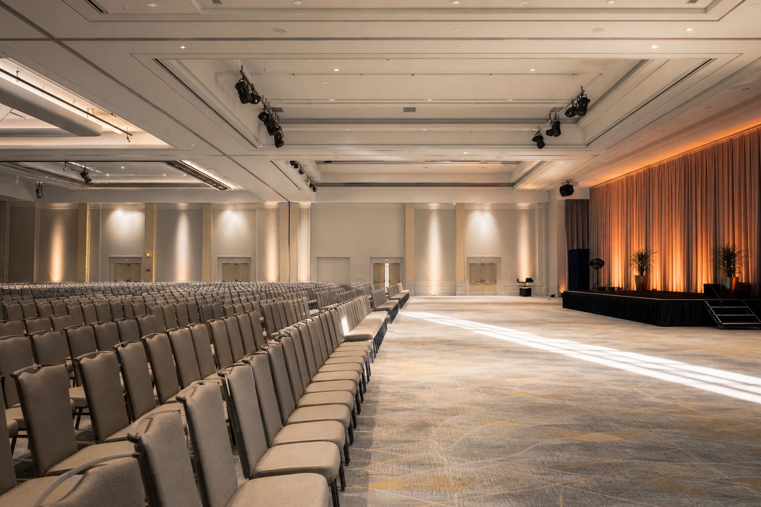 Bright empty conference hall with amber stage light washing one side of the room